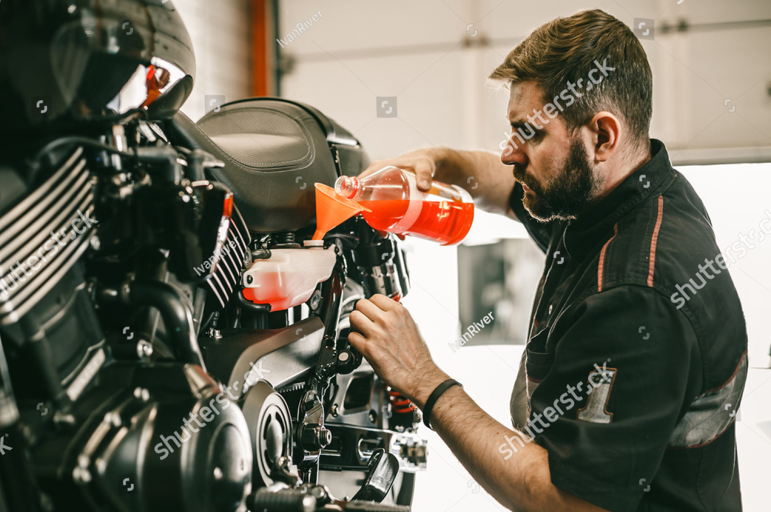 stock-photo-professional-mechanic-pouring-antifreeze-into-a-motorcycle-confident-young-man-repairing-668524327